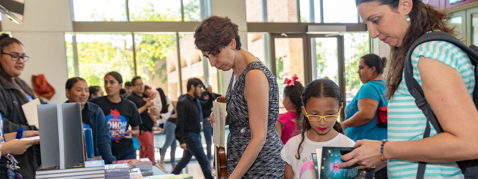 Community mom and child looking at books.