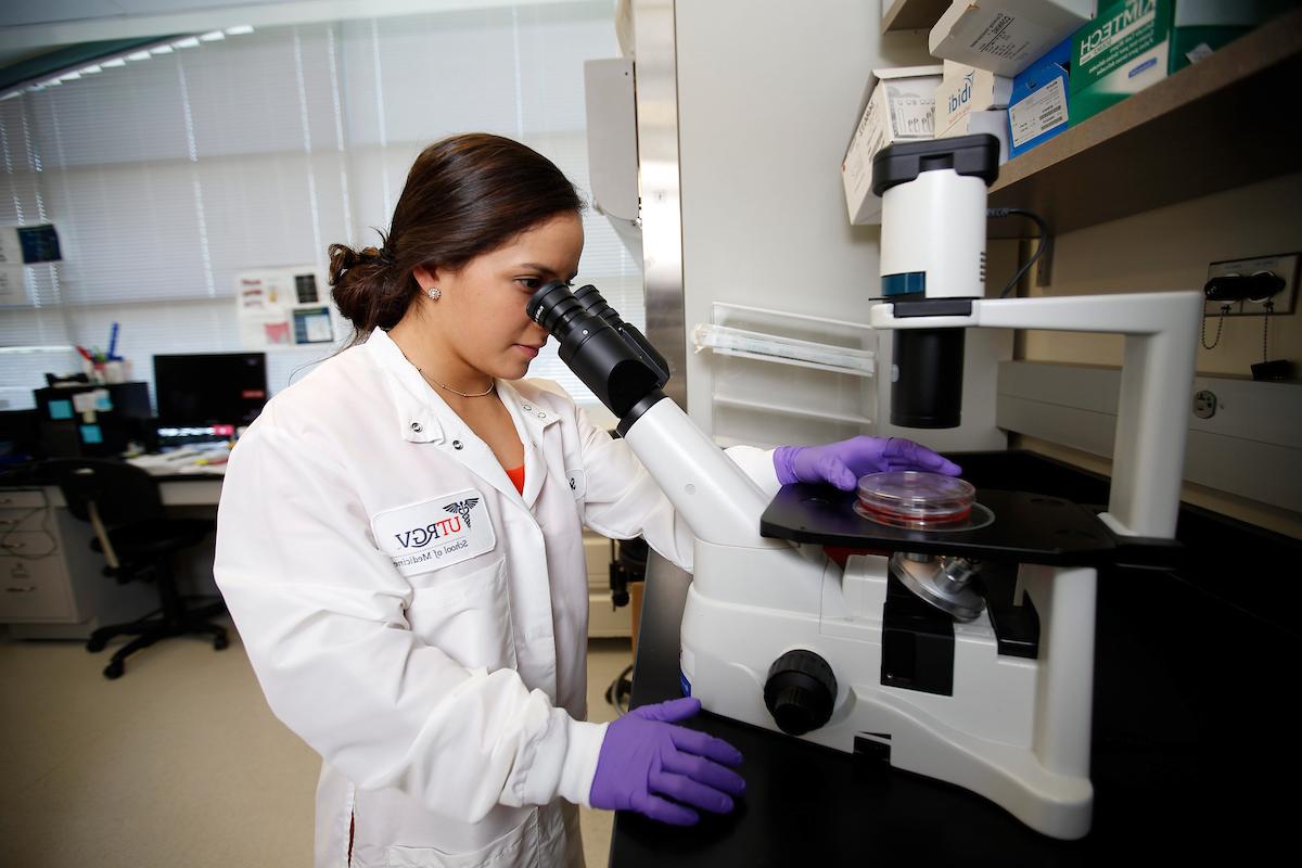 student looking into a microscope